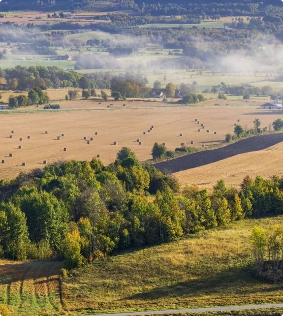 Översiktsbild av vidsträckt landskap med åkrar. Vi verkar över hela Stockholms landsbygd.