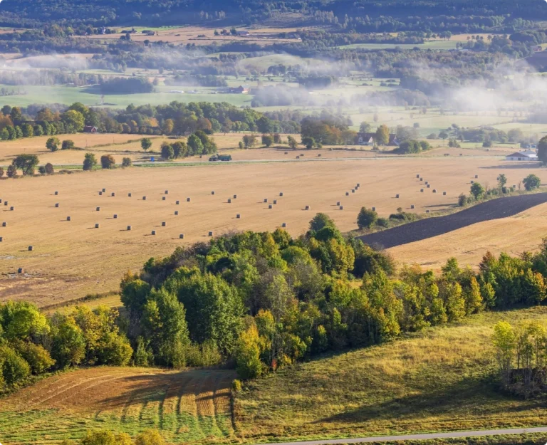 Översiktsbild av vidsträckt landskap med åkrar. Vi verkar över hela Stockholms landsbygd.